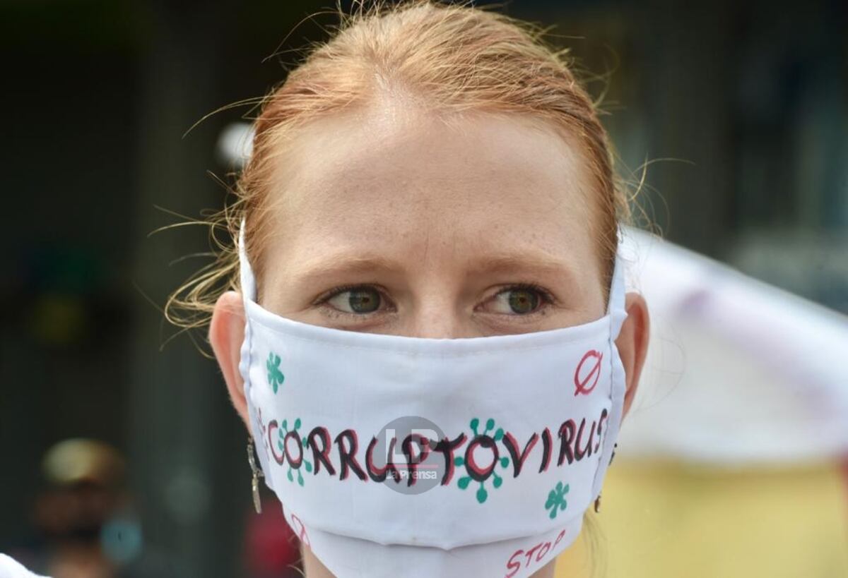 Detrás de la pancarta, una mujer