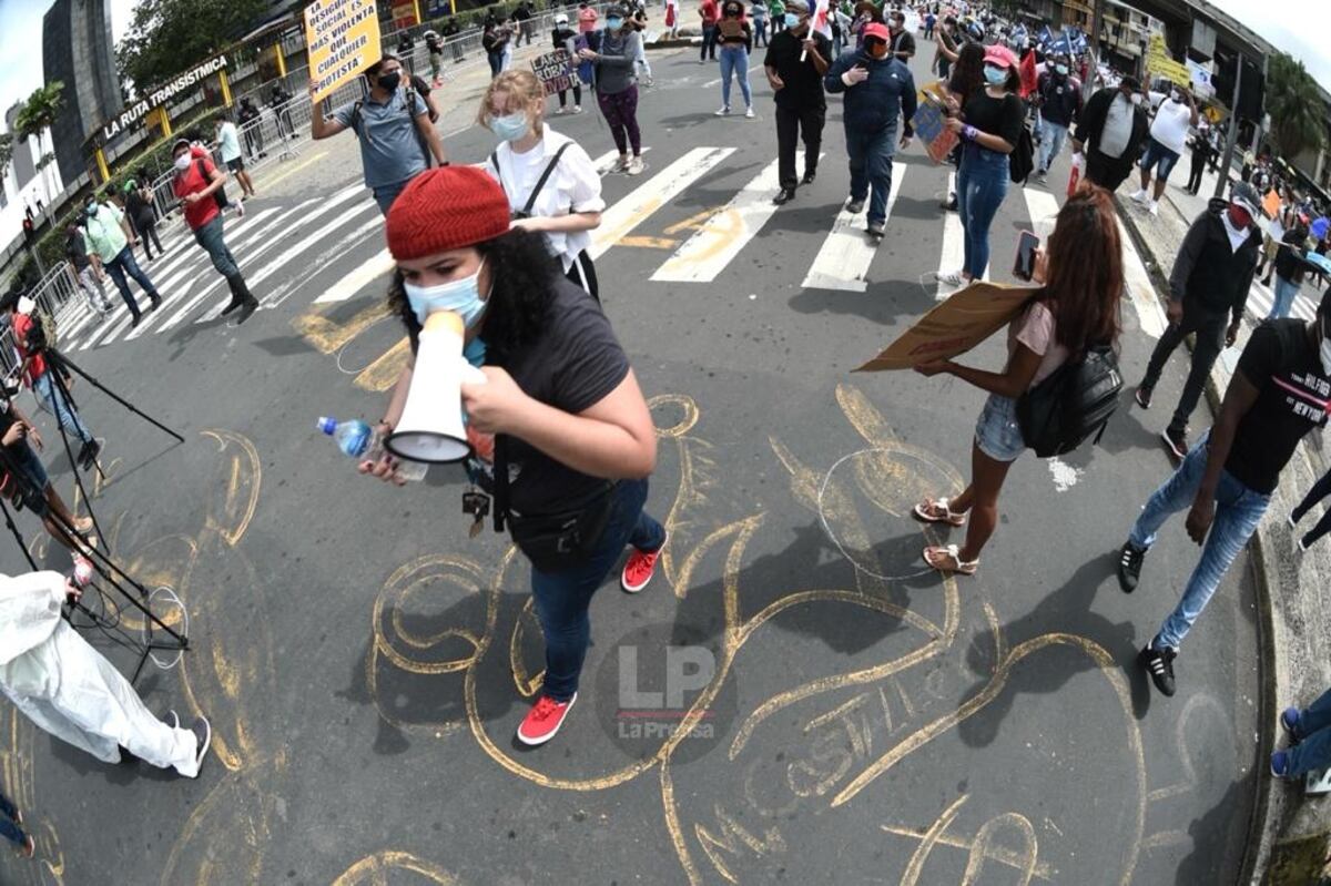 Detrás de la pancarta, una mujer