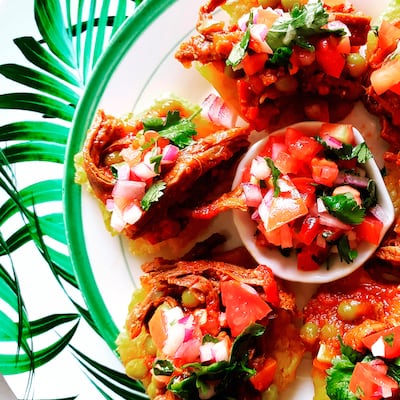 Patacones coronados con ropa vieja y pico de gallo
