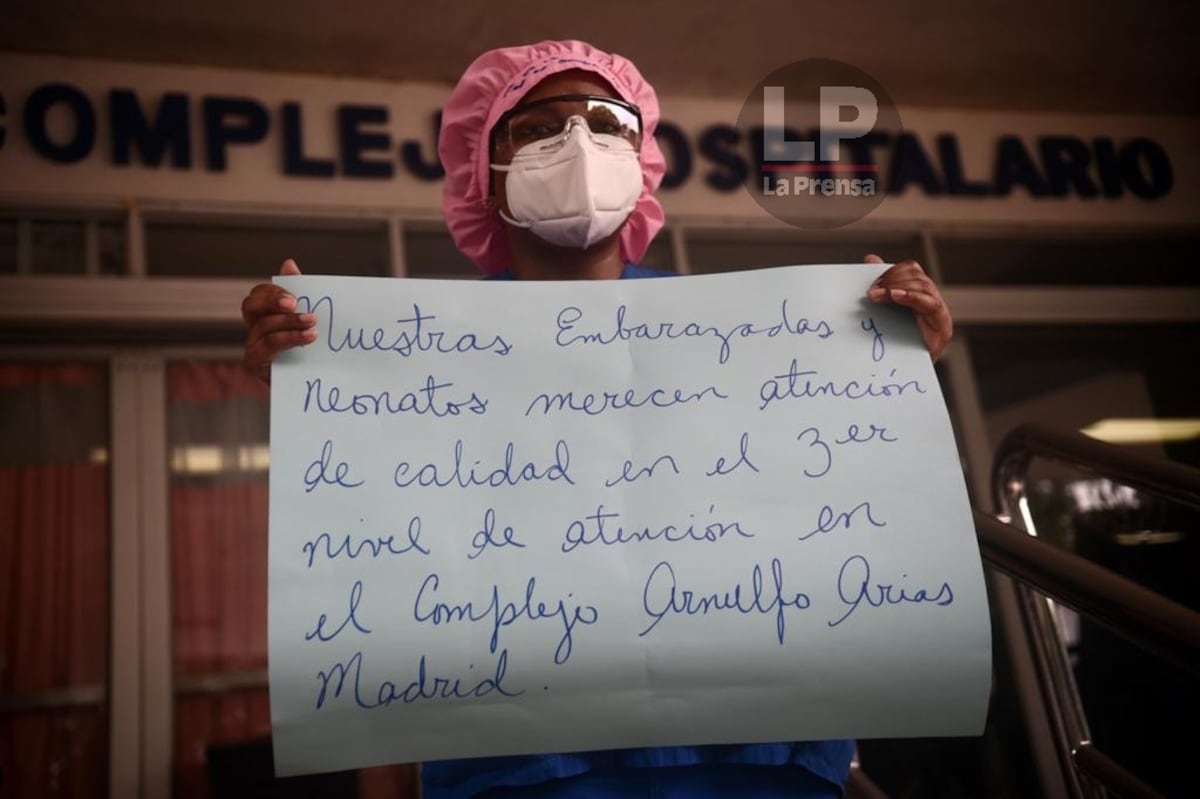 Detrás de la pancarta, una mujer