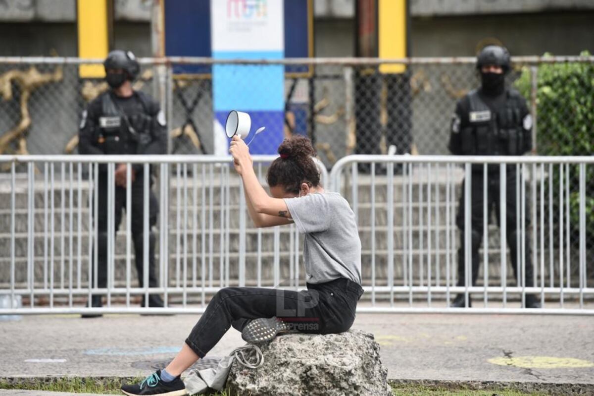 Detrás de la pancarta, una mujer