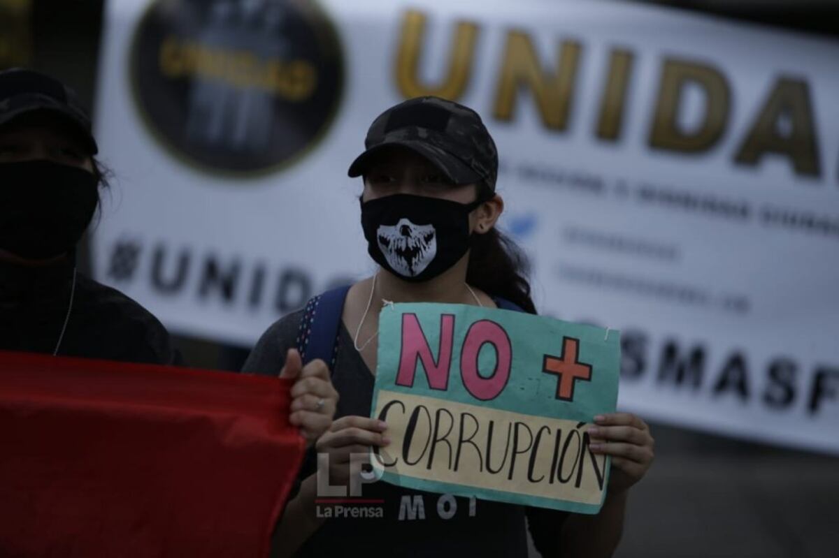 Detrás de la pancarta, una mujer