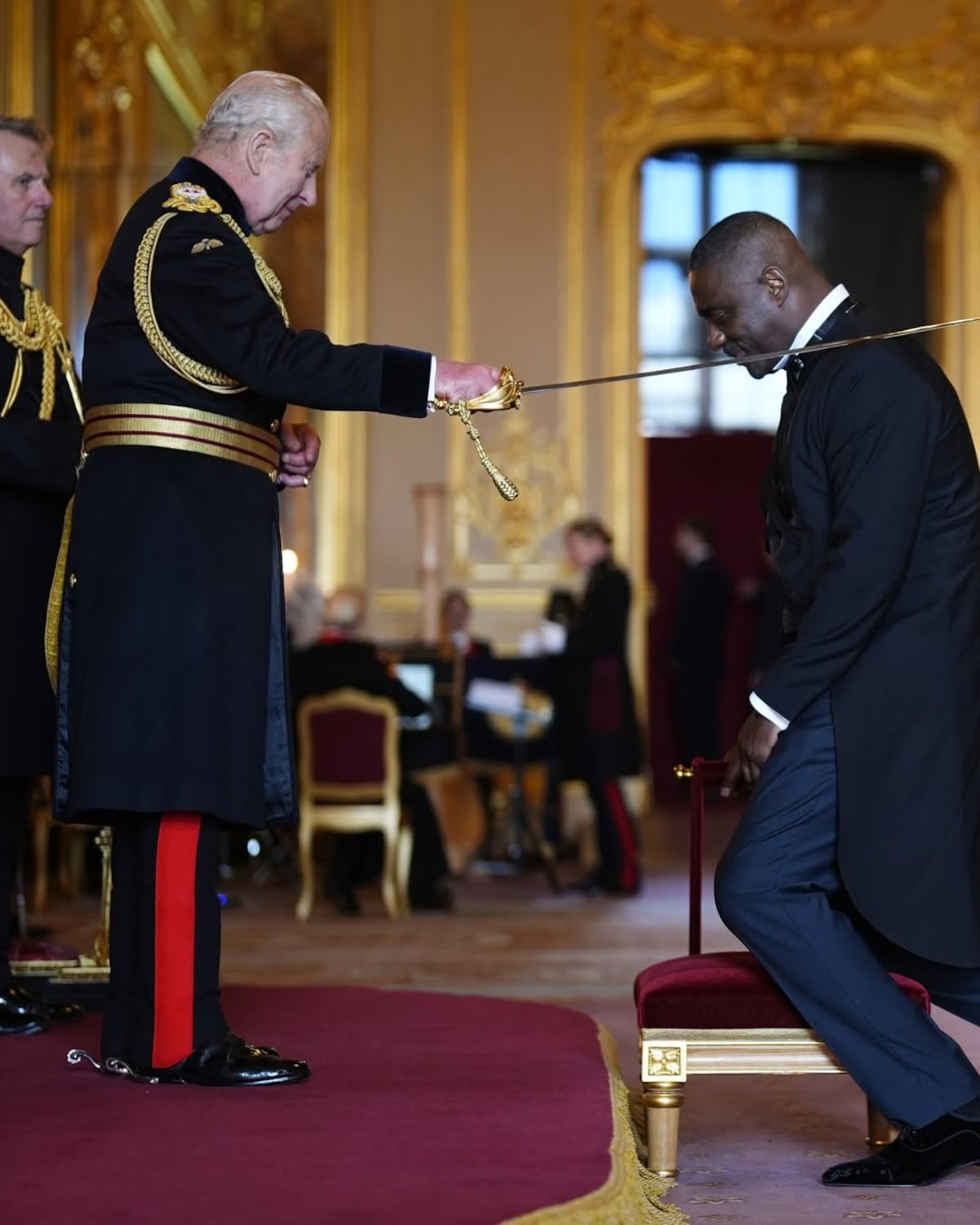 El actor británico Idris Elba recibe el título de 'caballero' por parte del rey Carlos III